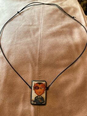 Artistic Black Cord Necklace with Orange Character Pendant